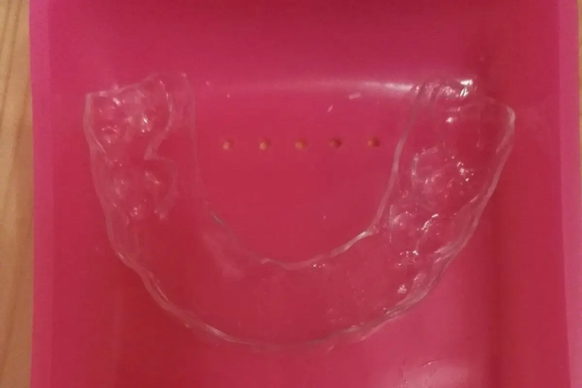 A clear plastic retainer lying in a pink case