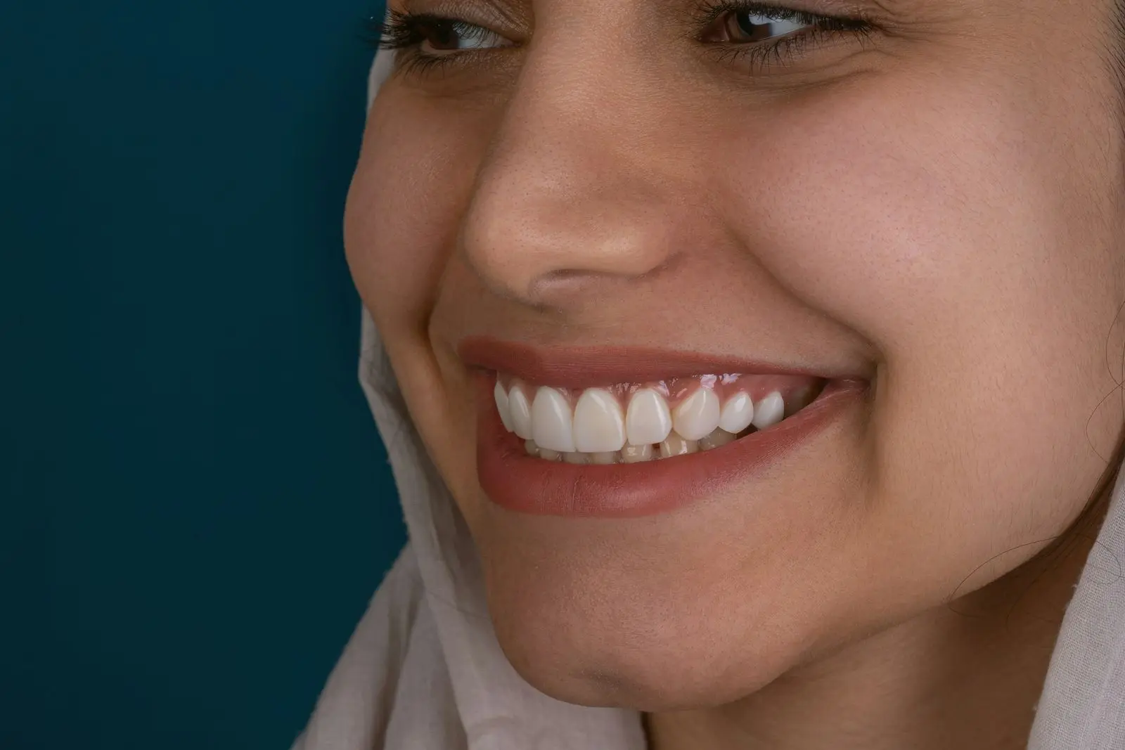 Close-up of a woman smiling in profile, showing even white front teeth